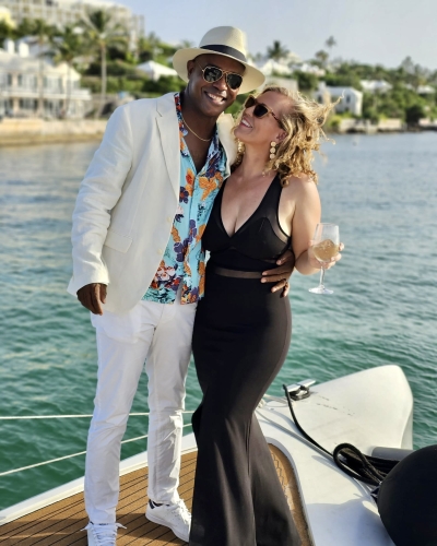 A couple is smiling on boat.