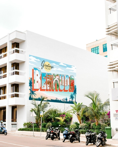 A sign painted on the side of a building that says "Greetings from Bermuda".