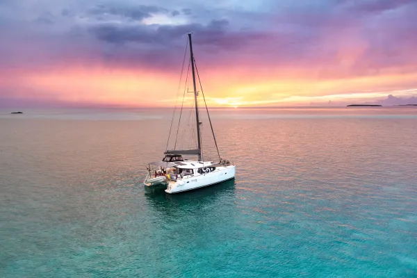 A boat in blue water at sunset