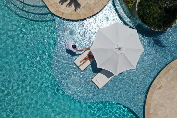 A man serving a woman drinks in a pool