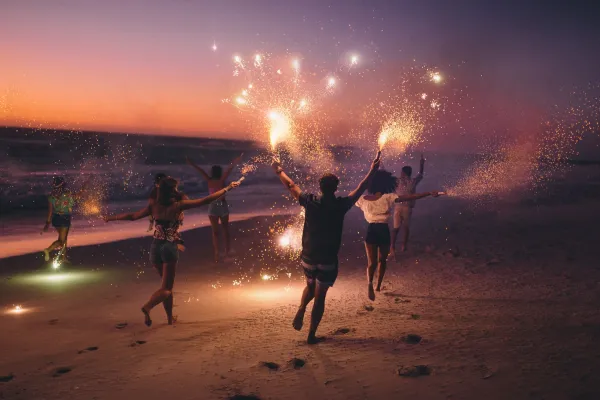 People running along the beach with sparklers