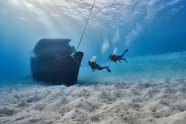 A couple snorkeling in Bermuda near a shipwreck 