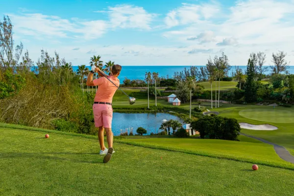 A man teeing off on a golf course in Bermuda