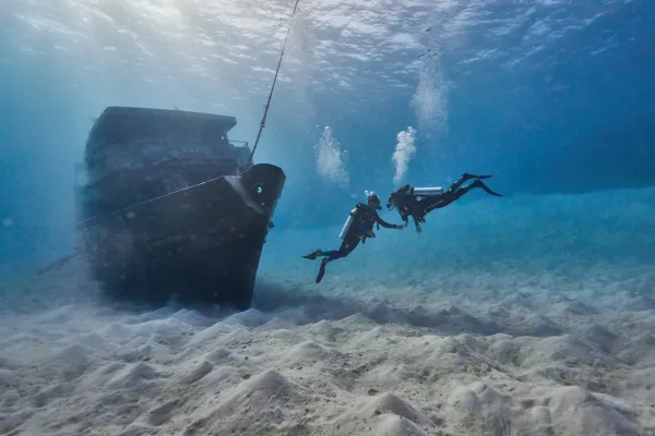 A couple scuba diving near a shipwreck in Bermuda