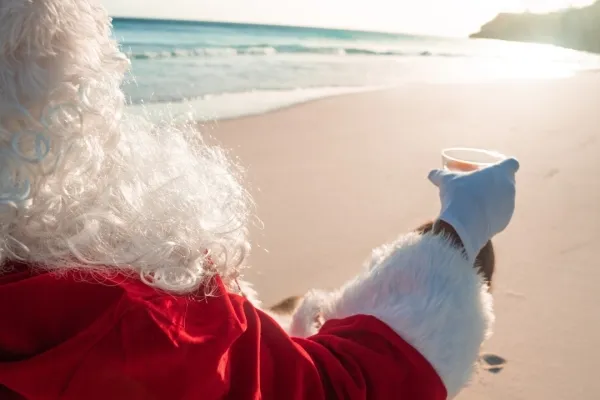 Santa Claus sitting in a beach chair holding a drink
