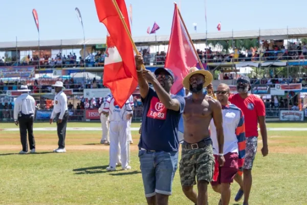 People carrying flags in a pre-match ceremony for the cricket Cup Match in Bermuda