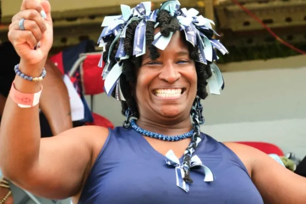 A spectator cheering and waving a cowbell at the cricket Cup Match in Bermuda