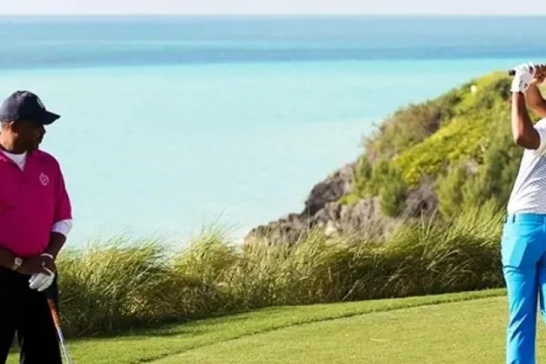 Two golfers warming up on a Bermuda golf course
