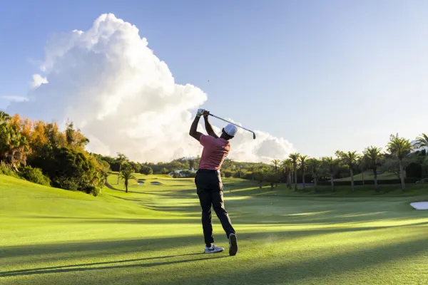 A man takes a swing on a golf course fairway in Bermuda