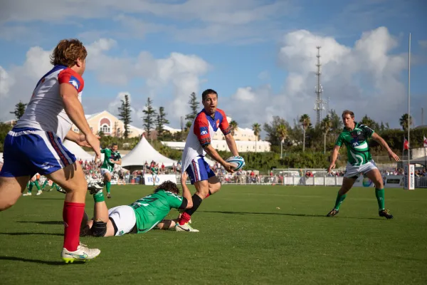 A man passes to his teammate while avoiding a tackle a during the rugby classic in Bermuda
