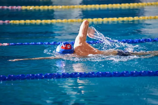 A man with a Bermudian swim cap swims lanes at the National Sports Centre