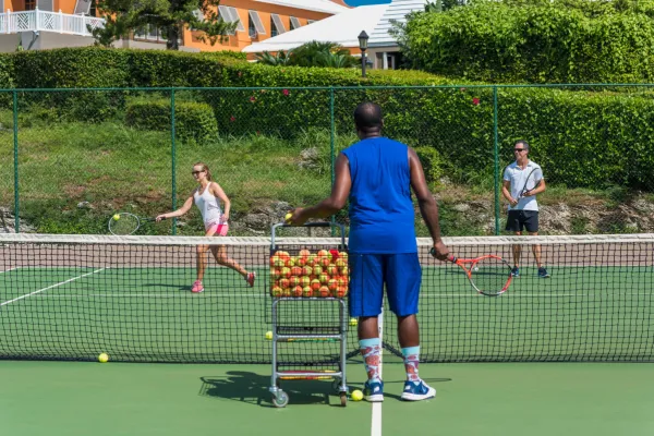 A woman takes a lesson at a Bermuda tennis court