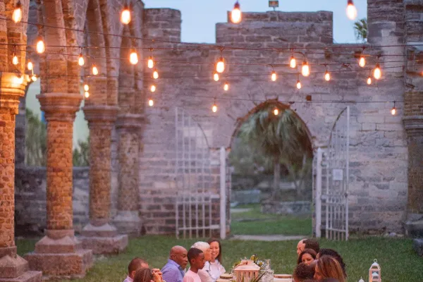 A family enjoying an outdoor dinner at the Unfinished Church in Bermuda