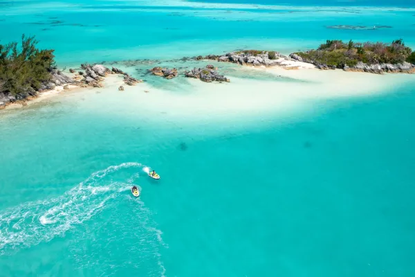 Two jet skis zoom around a Bermudian bay