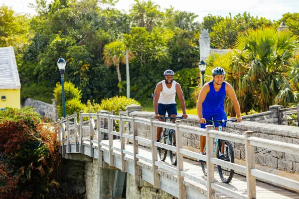 Two males on bikes riding over bridge