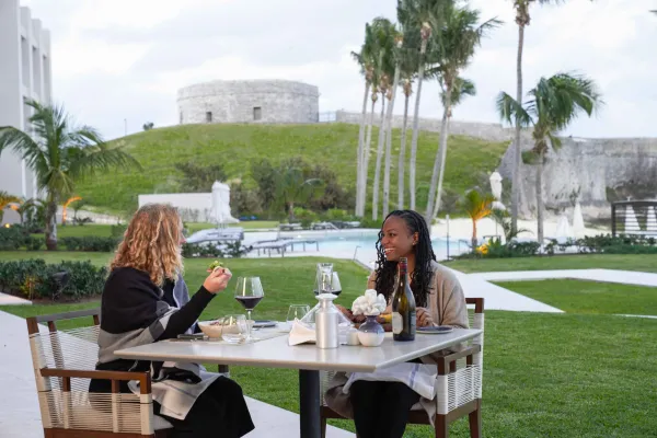 Two women dining outside in view of a fort