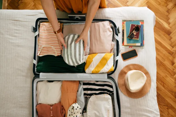 A person packing a suitcase for a sunny vacation