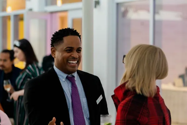 Two people chatting in a reception area at the Bermuda Tourism Summit