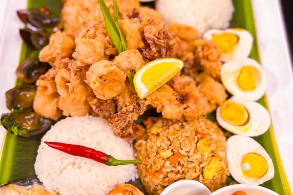 A close up of a plate of food on banana leaves. 
