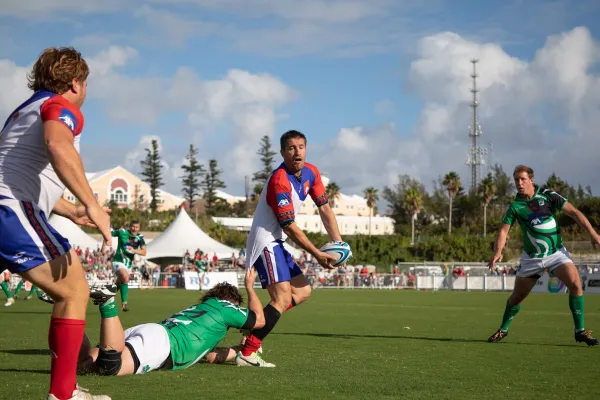 A rugby player tries to pass while being tackled during the Bermuda rugby classic