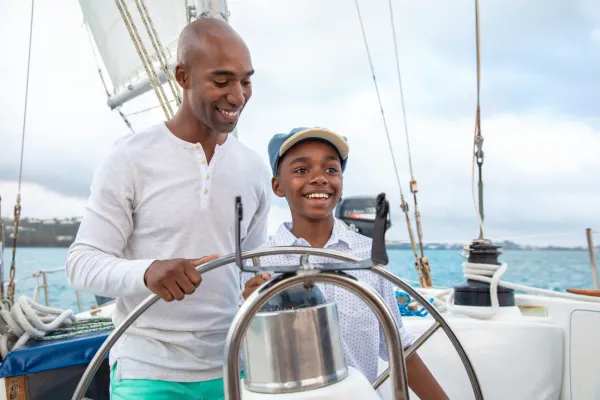 A father and son steering a boat