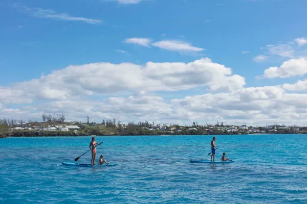 A family is paddleboarding by the Vixen in Bermuda