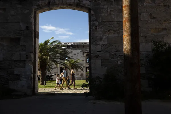 A long distance view of a family walking through old buildings in Dockyard.