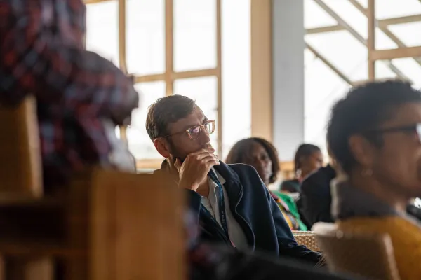 A man listening to a speech at a Bermuda Tourism Summit event