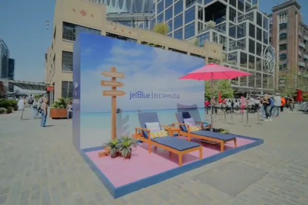 Two lounger chairs set up in front of a Bermuda beach scene for a JetBlue tourism activation