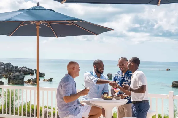 A group of guys are smiling by a scenic view.