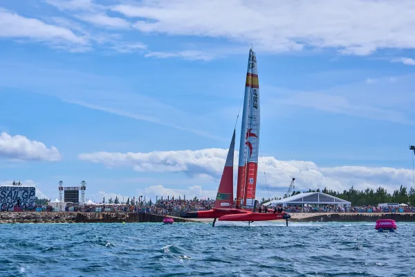 A Sail GP boat is flying across the finish line.