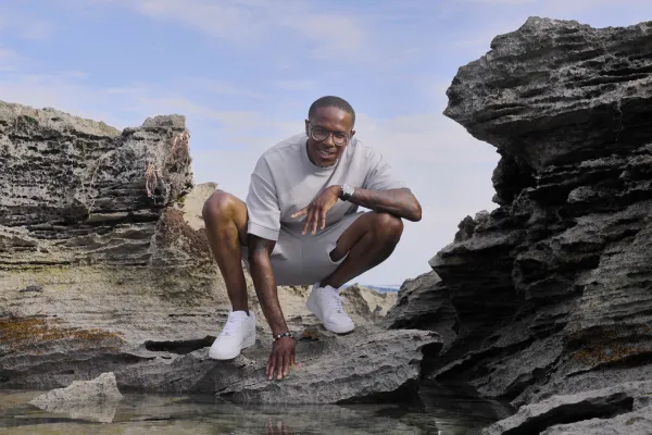 Steven Douglas is posing on a rock 