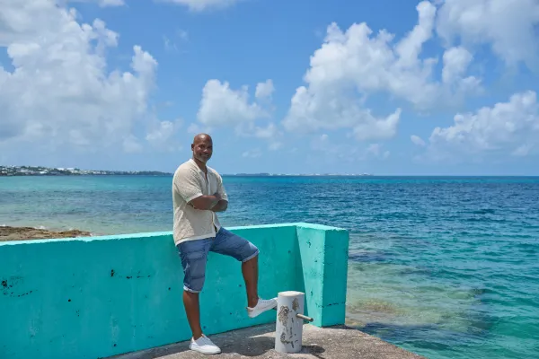 John Nusum is standing by the ocean