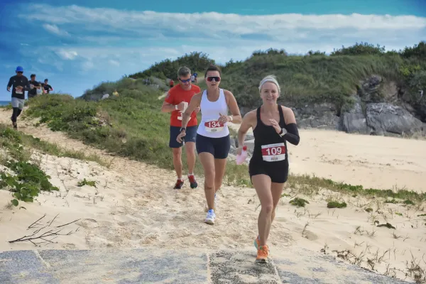 A group of people are running on the beach