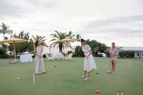 A group of women are playing croquet.