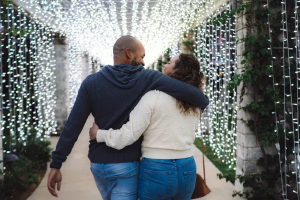 A couple is walking down a lighted alley.