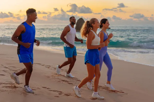 A group of friends are running on the beach.