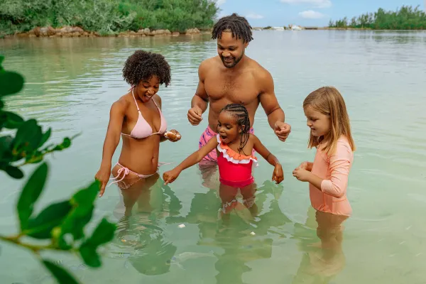 A family is in the water feeding fish.