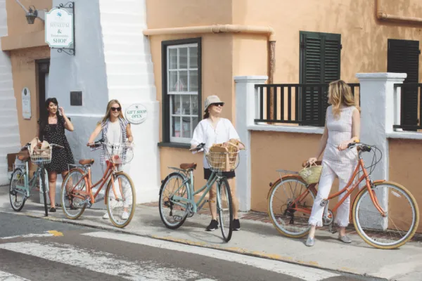 Four women walking their bikes