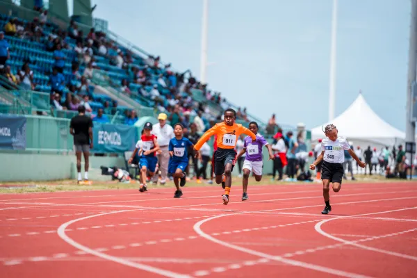 Little kids are running on a track.