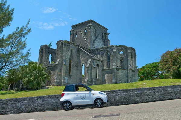A microcar is driving passed the unfinished church