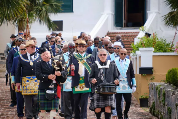 A group of men are walking during the Peppercorn Ceremony