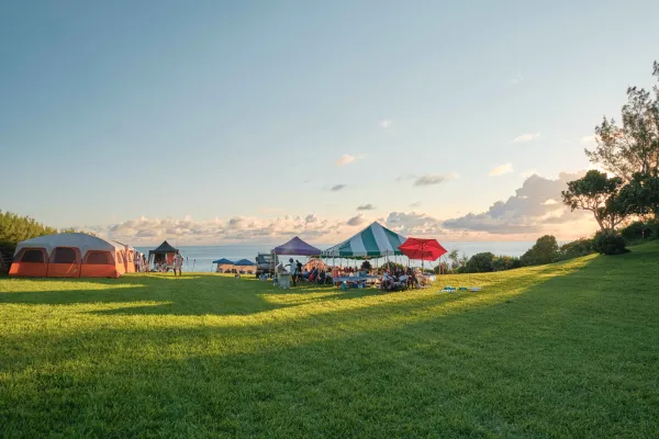 A family are camping by the waterside at Cup Match.