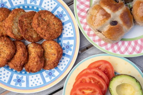Plates filled with fishcakes and hot cross buns.
