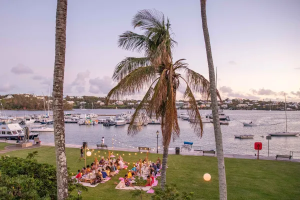 A group of people are sitting at an outdoor picnic.