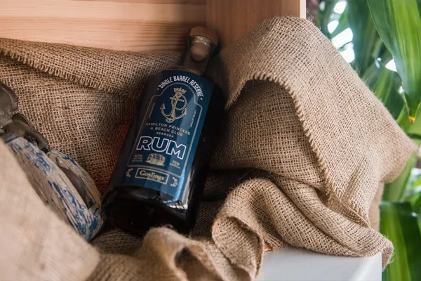 A bottle of dark rum on a burlap sack