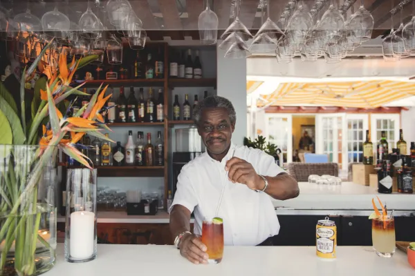 A bartender stirring a Dark n Stormy behind the bar in Bermuda