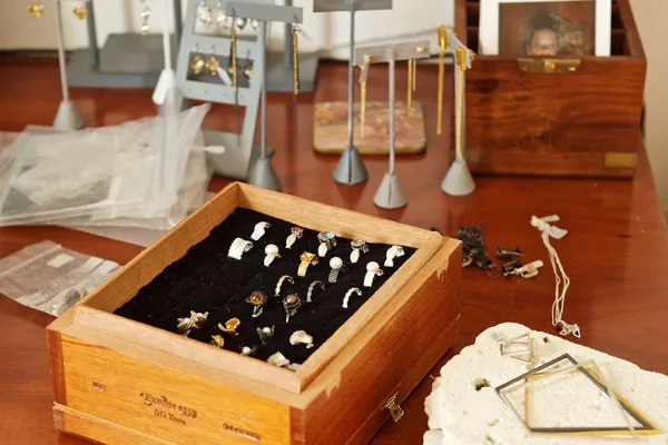 Wooden table of jewelry boxes and holders including rings, earings and neckalces.