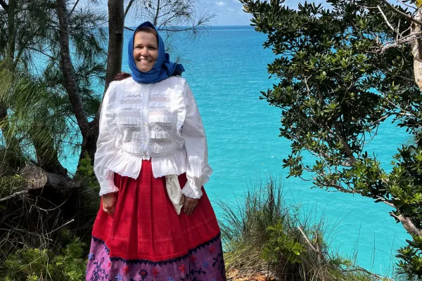 A woman is posing in traditional portuguese regalia.