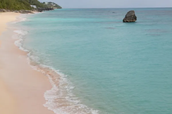 A pink sand beach with turquoise waters.